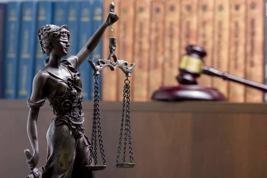 Legal Law concept - Open law book with a wooden judges gavel on table in a courtroom or law enforcement office. Copy space for text