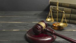 Legal Law concept - Open law book with a wooden judges gavel on table in a courtroom or law enforcement office. Copy space for text