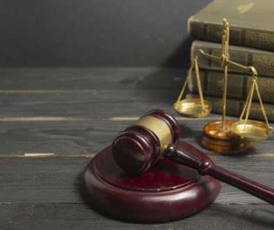 Legal Law concept - Open law book with a wooden judges gavel on table in a courtroom or law enforcement office. Copy space for text